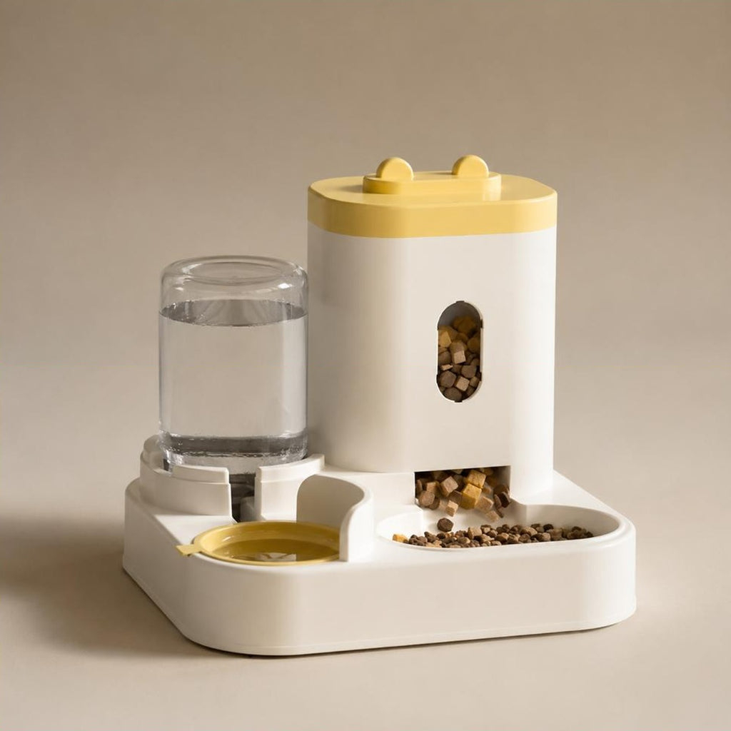 Gamelle double gravitaire Hortense jaune, reservoir de croquettes et bouteille d eau sur un socle creme