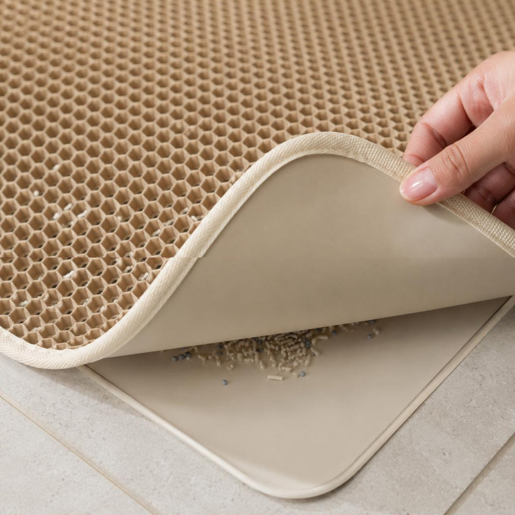 Gros plan sur la double couche du tapis Camille : alvéoles en nid d'abeille et litière retenue sous la couche étanche